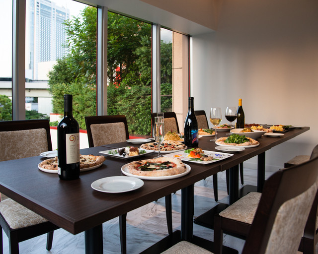 飯田橋ピアットのテーブル席|ワインとピッツァが並ぶ店内風景